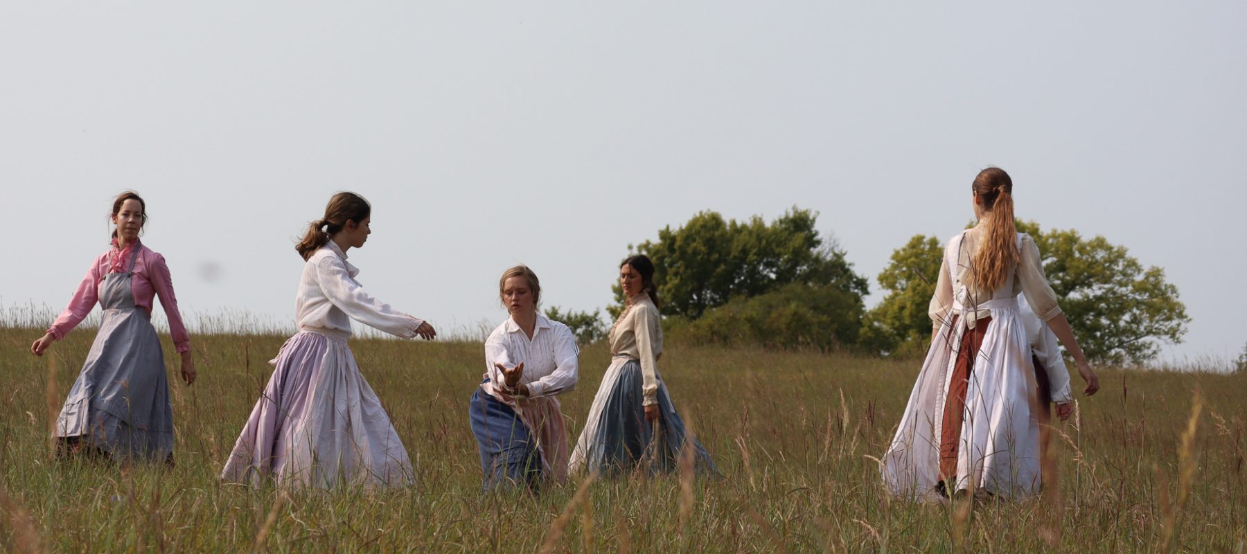 A group of people standing on top of a grass covered field