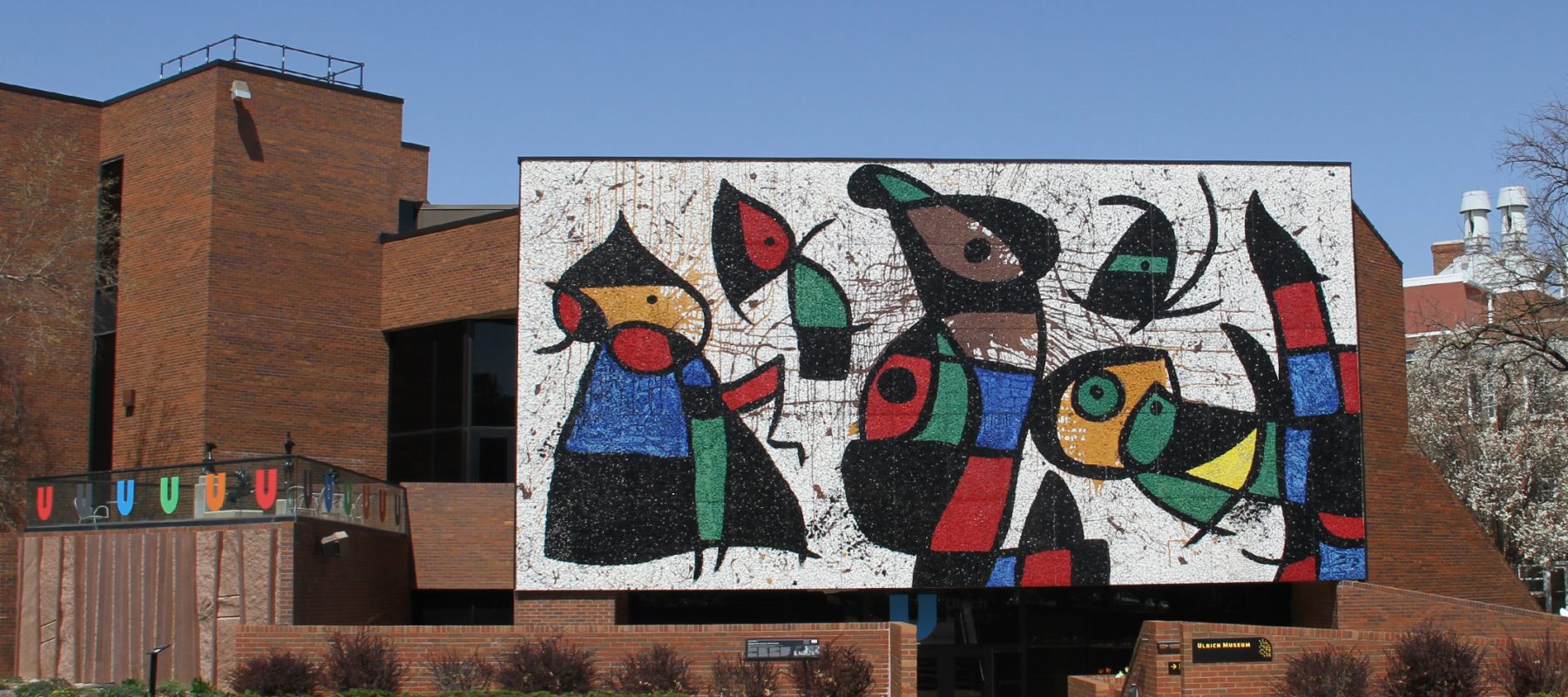 The front of the Ulrich Museum is pictured with a large, glass mural, Personnage Oiseaux, by Joan Miro.