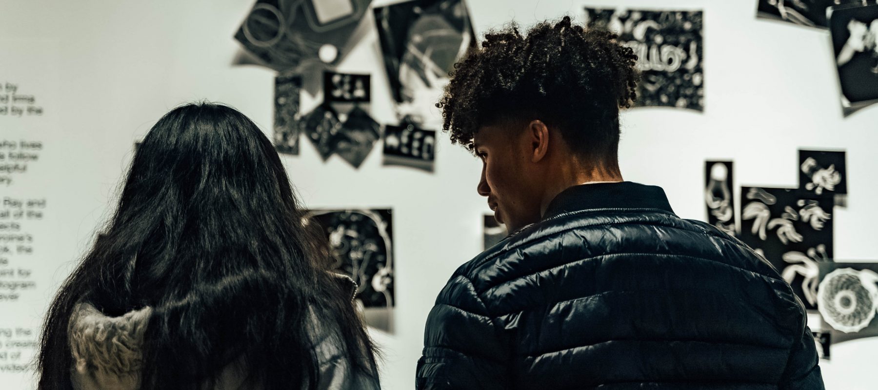 Young people look at photography in a gallery.