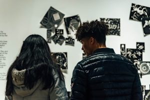 Young people look at photography in a gallery.
