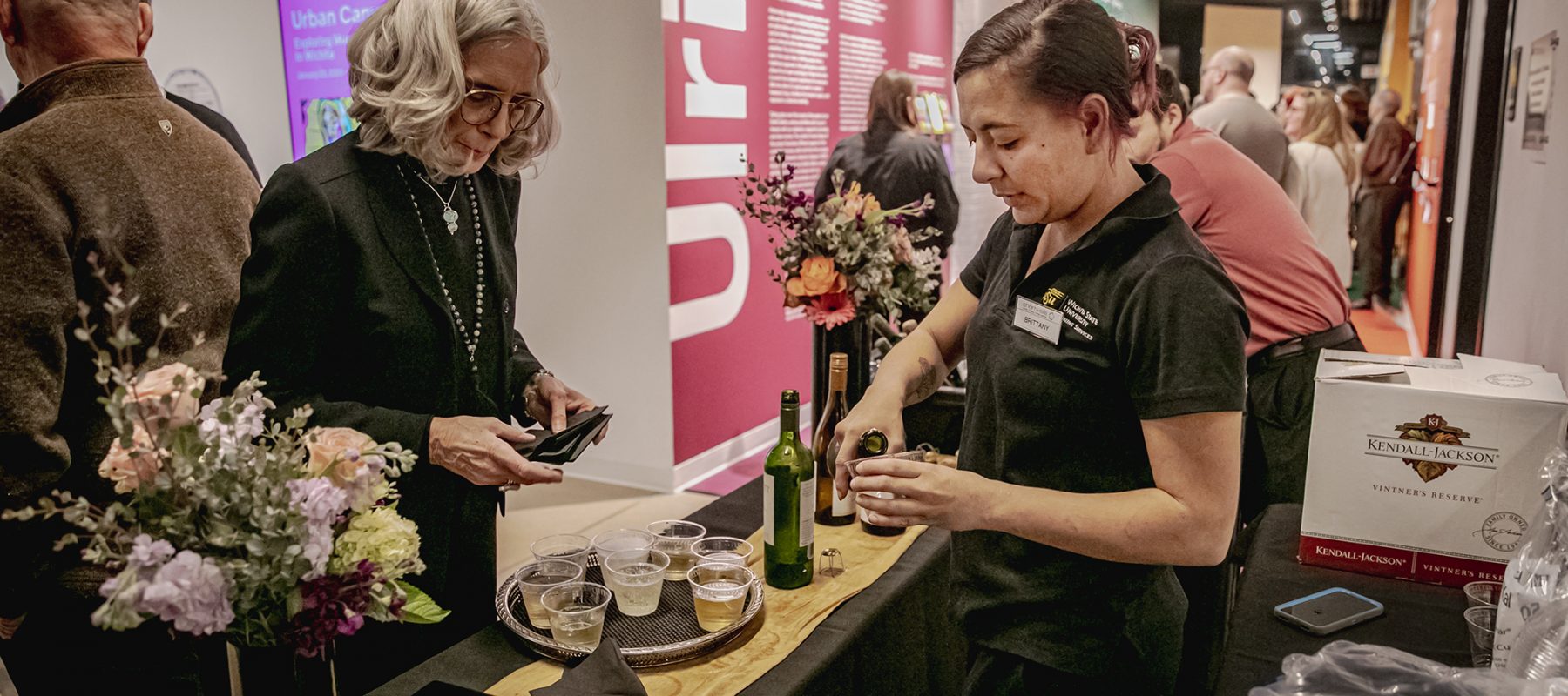 A woman prepares a drink for another woman in the lobby of the Ulrich.