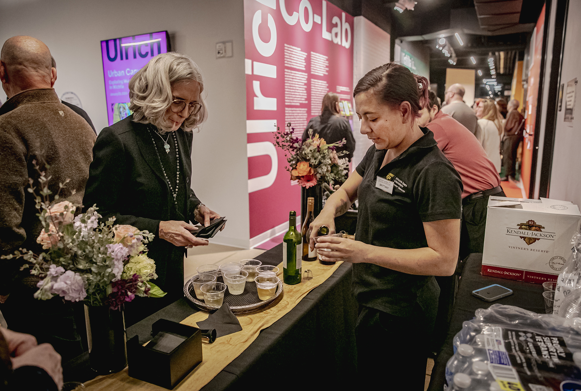 A woman prepares a drink for another woman in the lobby of the Ulrich.