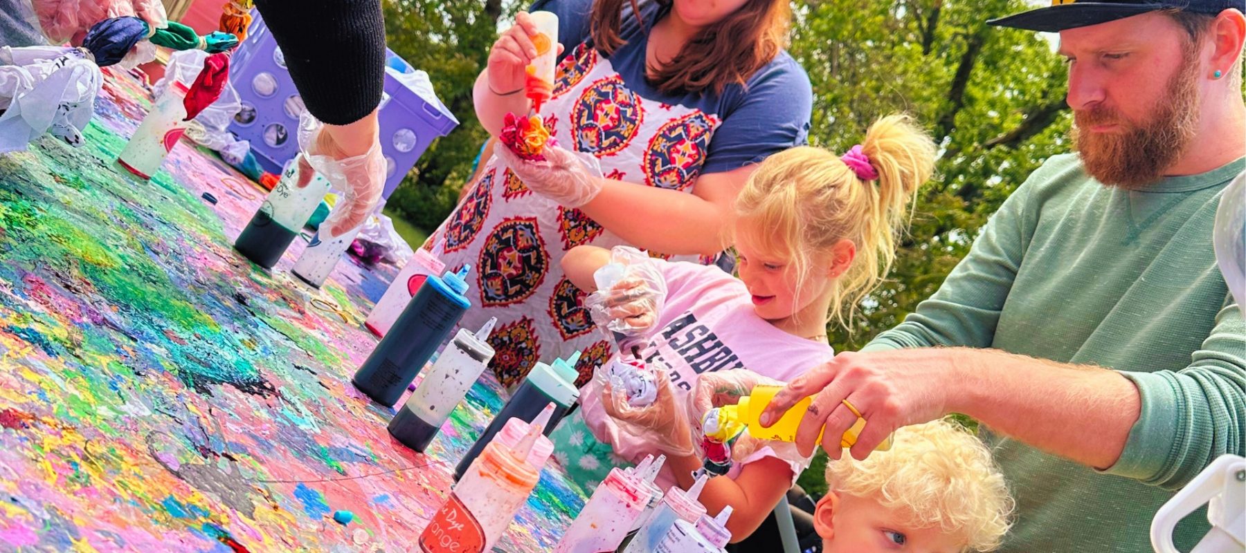 Two kids and two parents do tie dye together