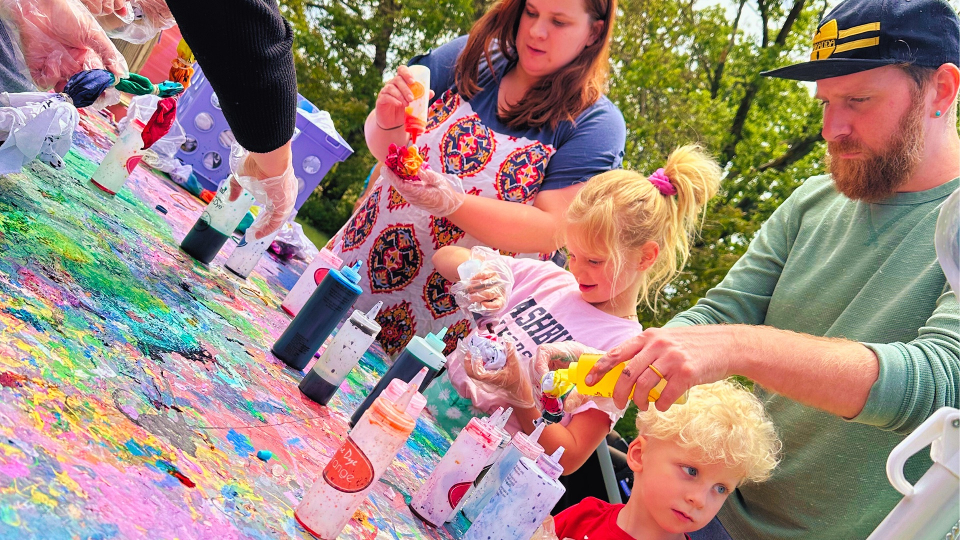 Two kids and two parents do tie dye together