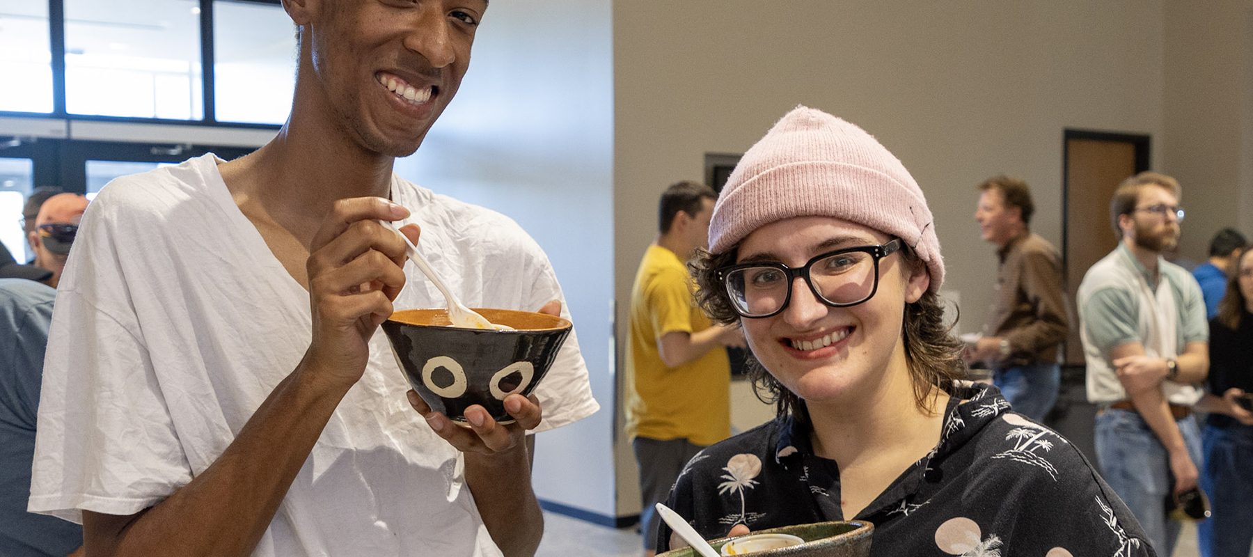 Two young men eat chili at a fundraiser.