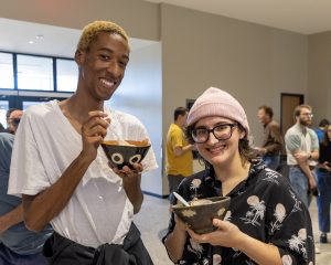 Two young men eat chili at a fundraiser.