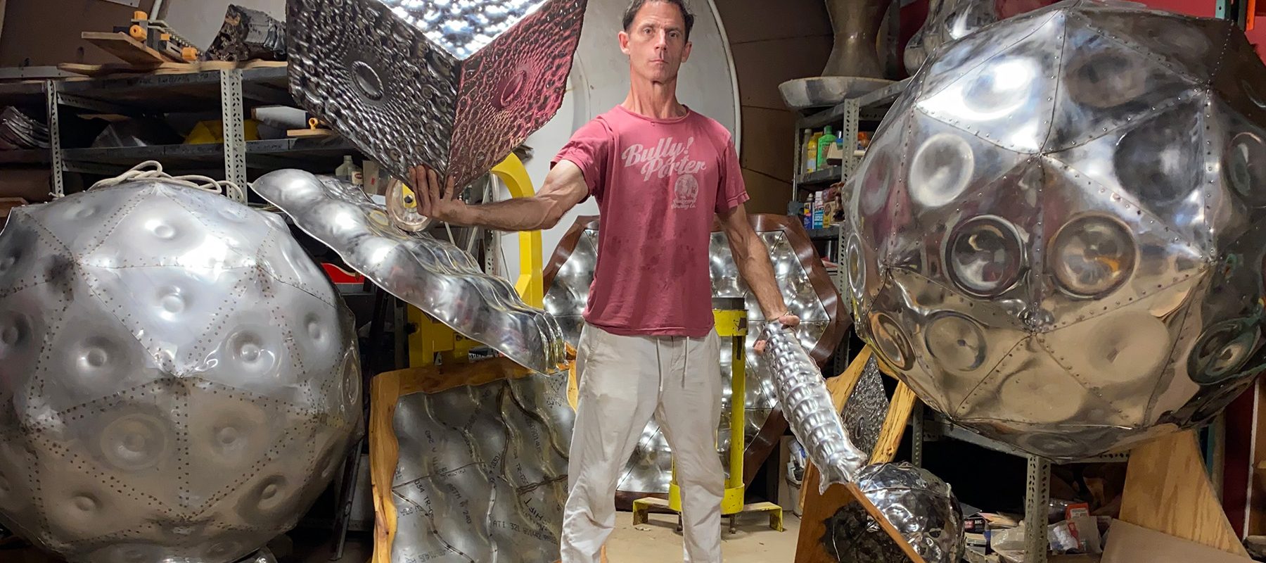 Artist Eric Schmidt poses with his large aluminum scluptures.