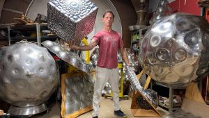 Artist Eric Schmidt poses with his large aluminum scluptures.