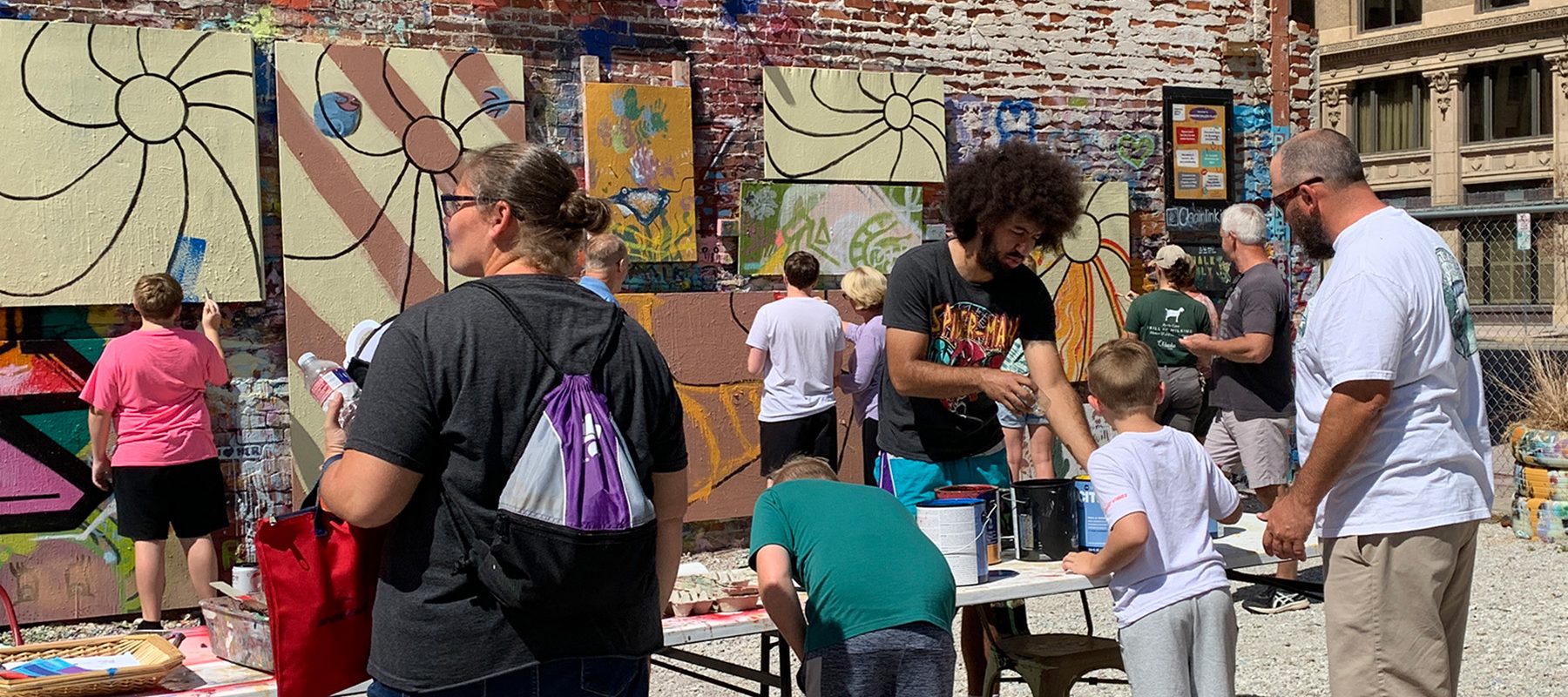 A man helps a family work on an art project.