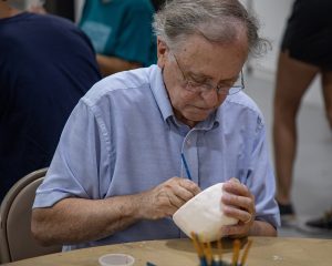 An senior man sculpts a bowl.