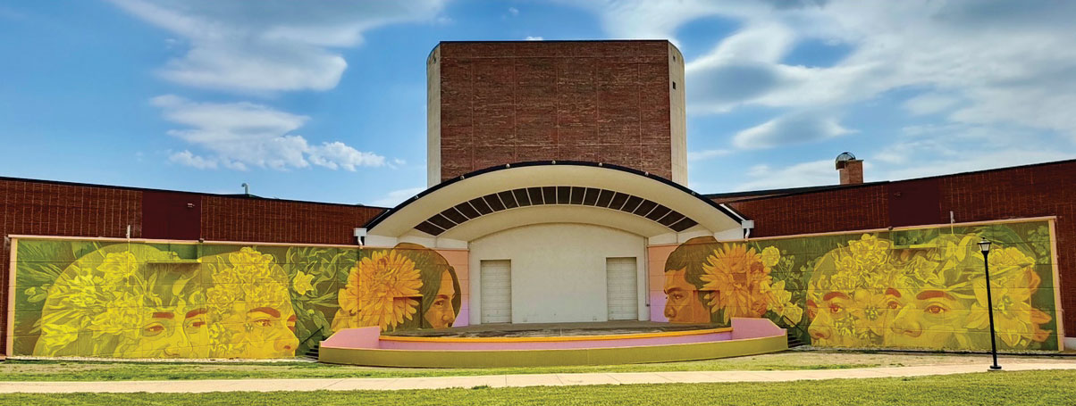 a vibrant mural of faces in primarily yellow hues surrounds Duerksen Amphitheater