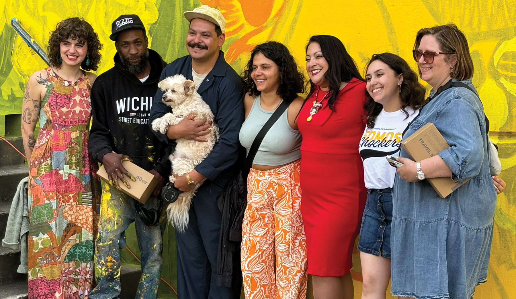 seven people line up in front of a colorful wall