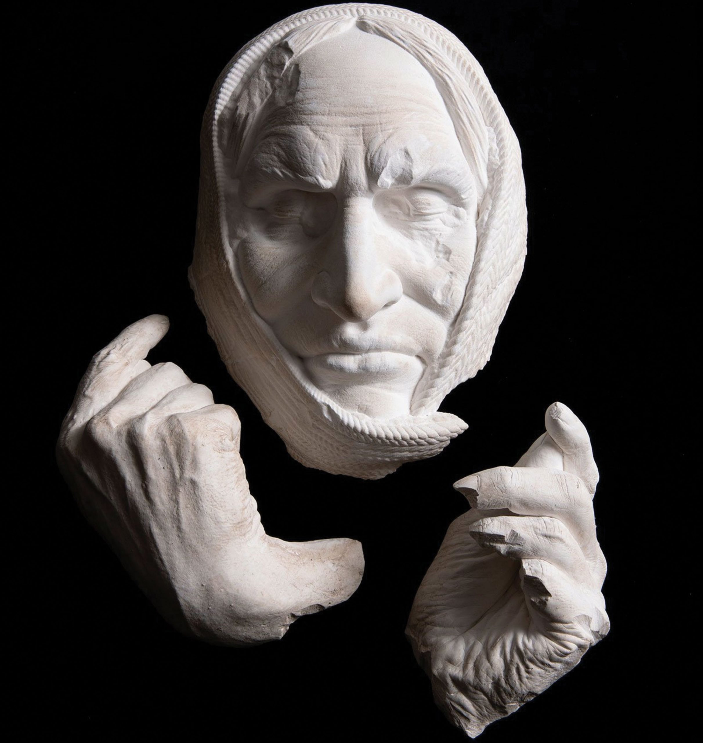 Plaster sculpture of a native American man's shrouded face and hands