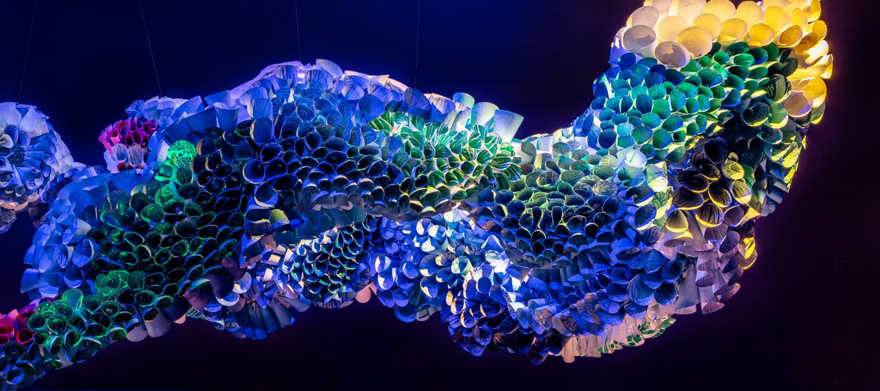 An abstract installation work by Abhidnya Ghuge, created from rolled, woodblock-printed paper plates inserted into a wire framework.