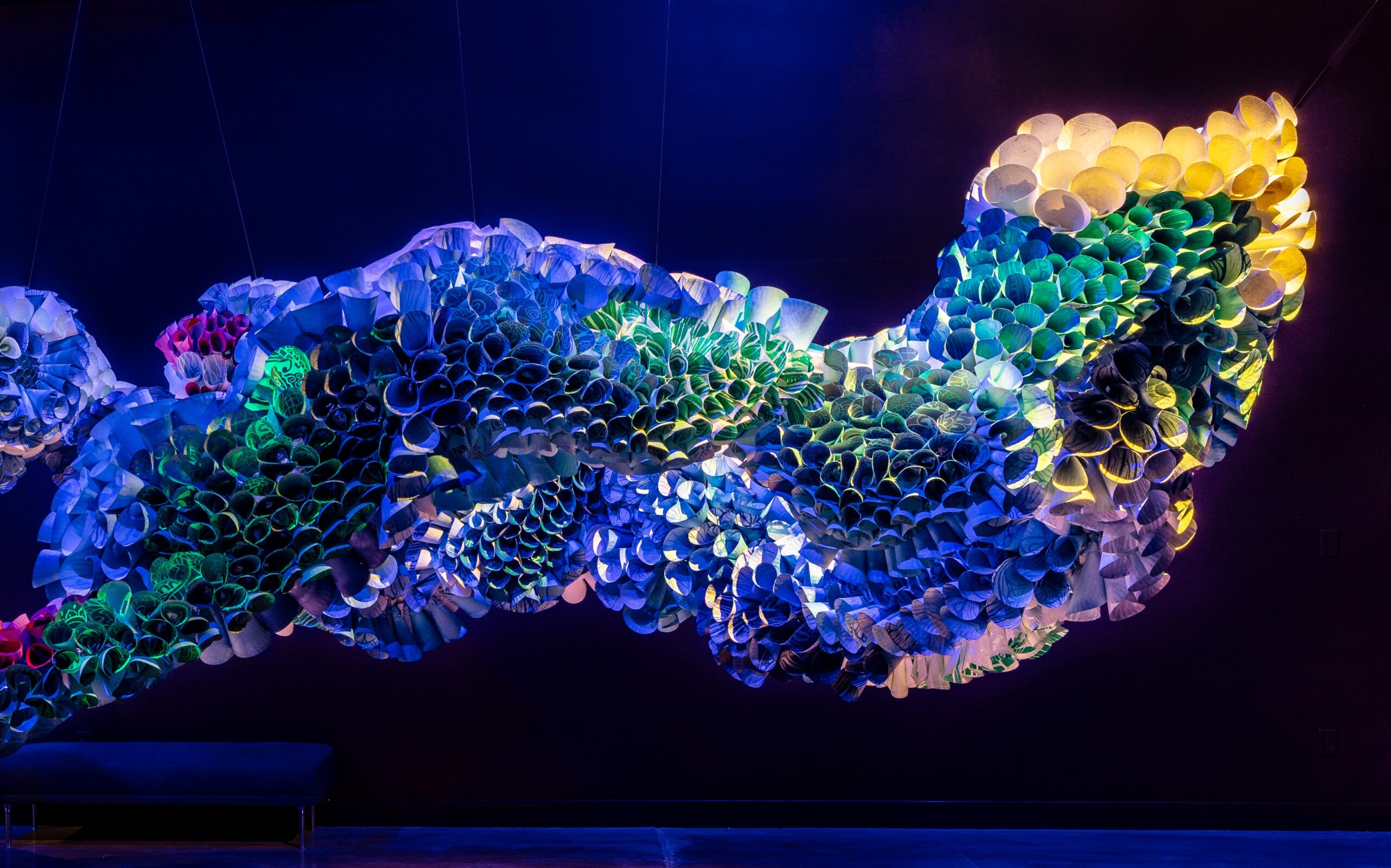 An abstract installation work by Abhidnya Ghuge, created from rolled, woodblock-printed paper plates inserted into a wire framework.