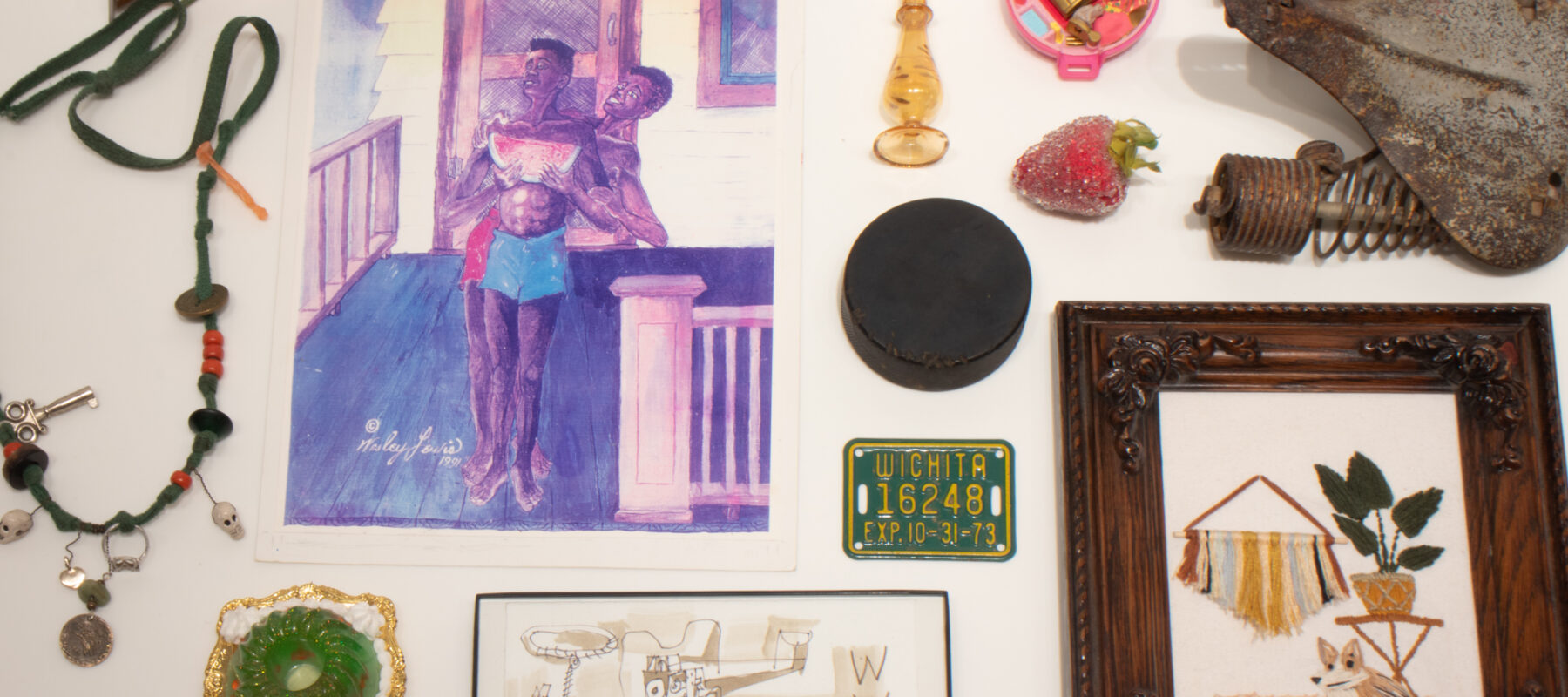 Personal objects: a perfume bottle, necklace, drawing, hockey puck, bike license tag, polly pocket doll, strawberry, and bicycle seat.