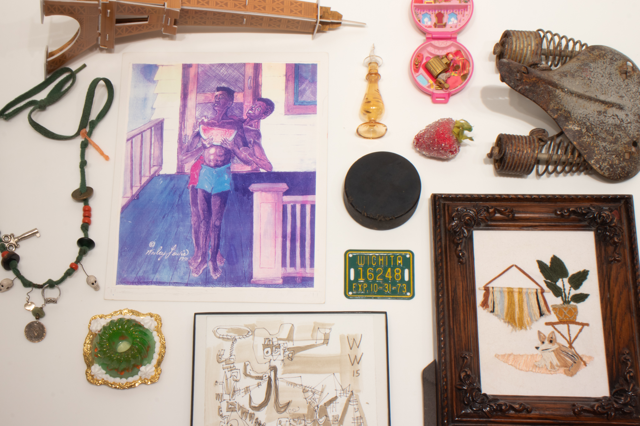 Personal objects: a perfume bottle, necklace, drawing, hockey puck, bike license tag, polly pocket doll, strawberry, and bicycle seat.