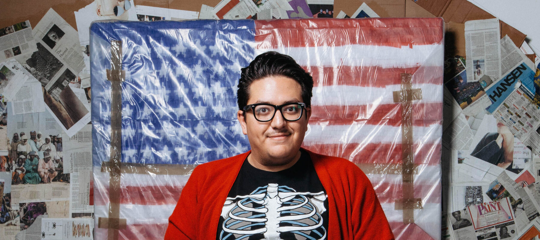 Artist Justin Favela in front of an American flag