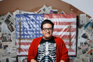 Artist Justin Favela in front of an American flag
