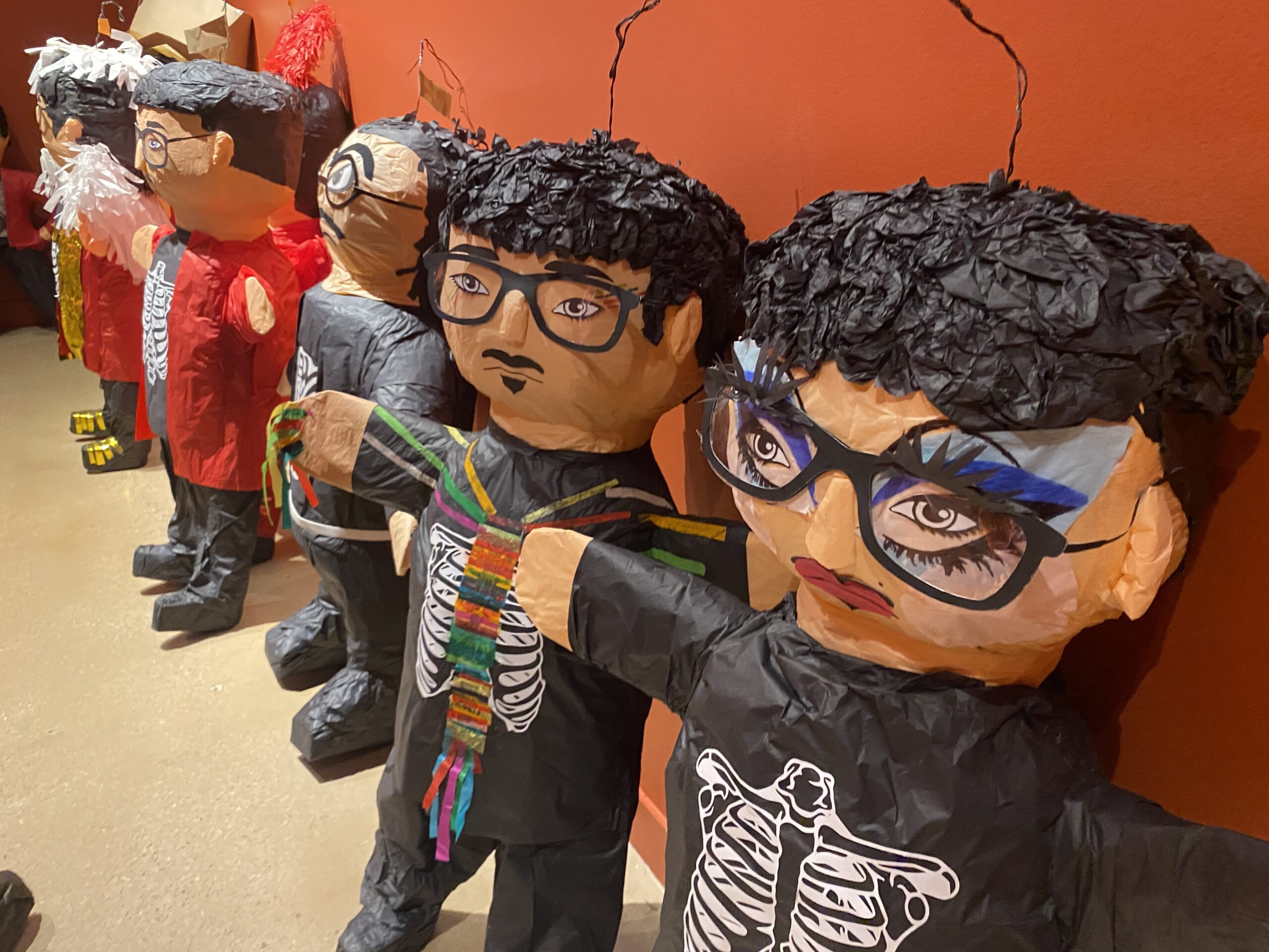 A line-up of piñatas made to look like the same man.