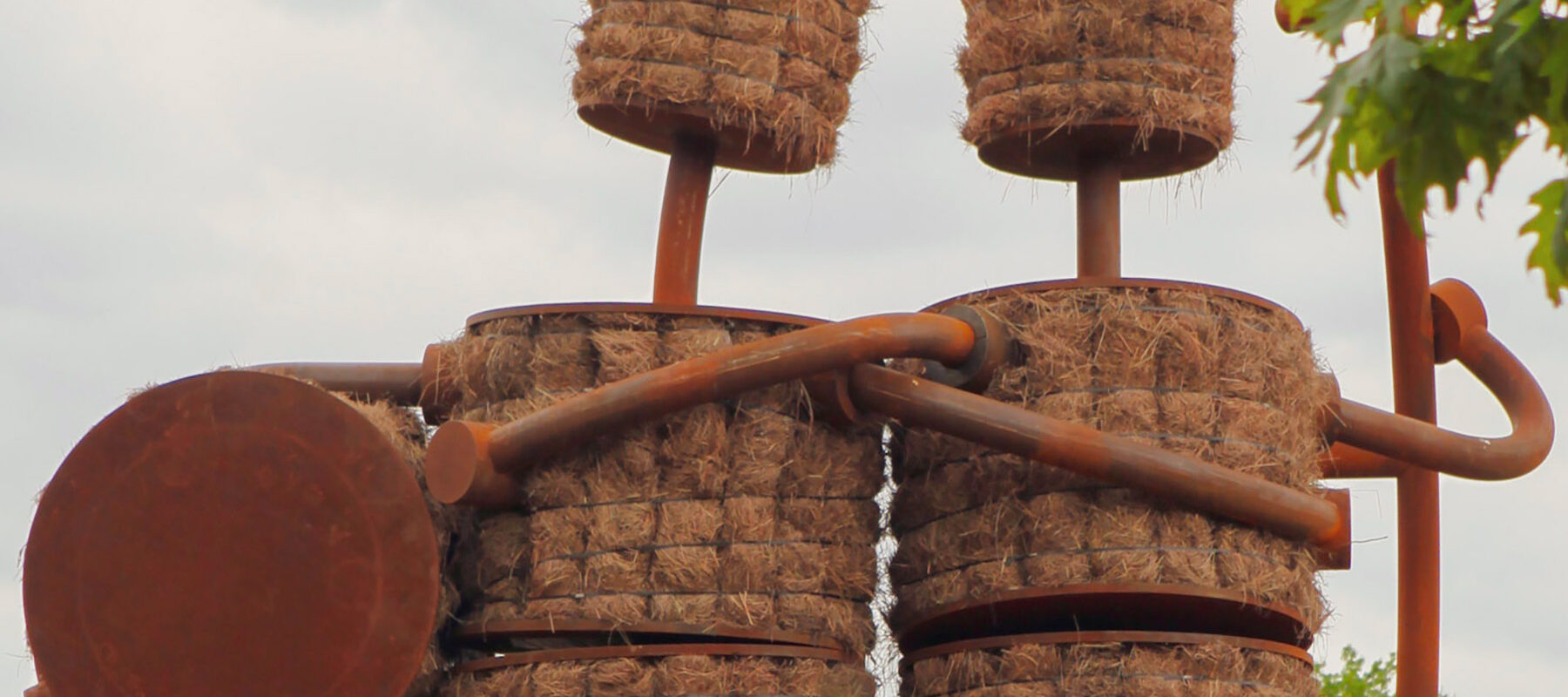 Sculpture by Tom Otterness, "Shockers," two figures made of bronze and hay, embracing.