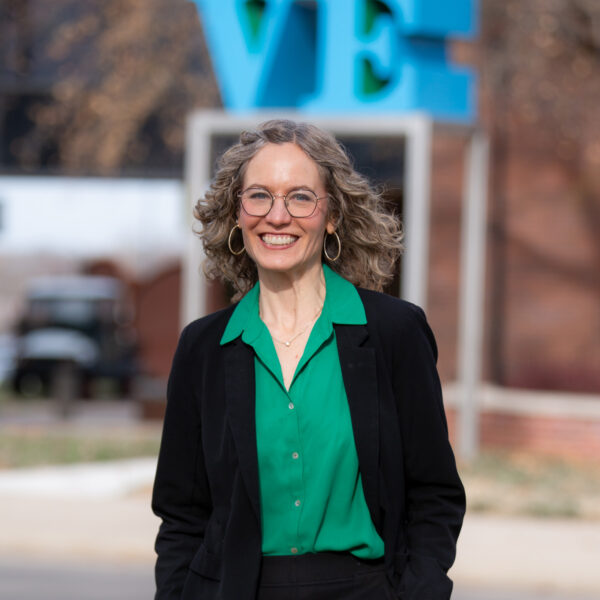 Smiling blond woman in glasses.