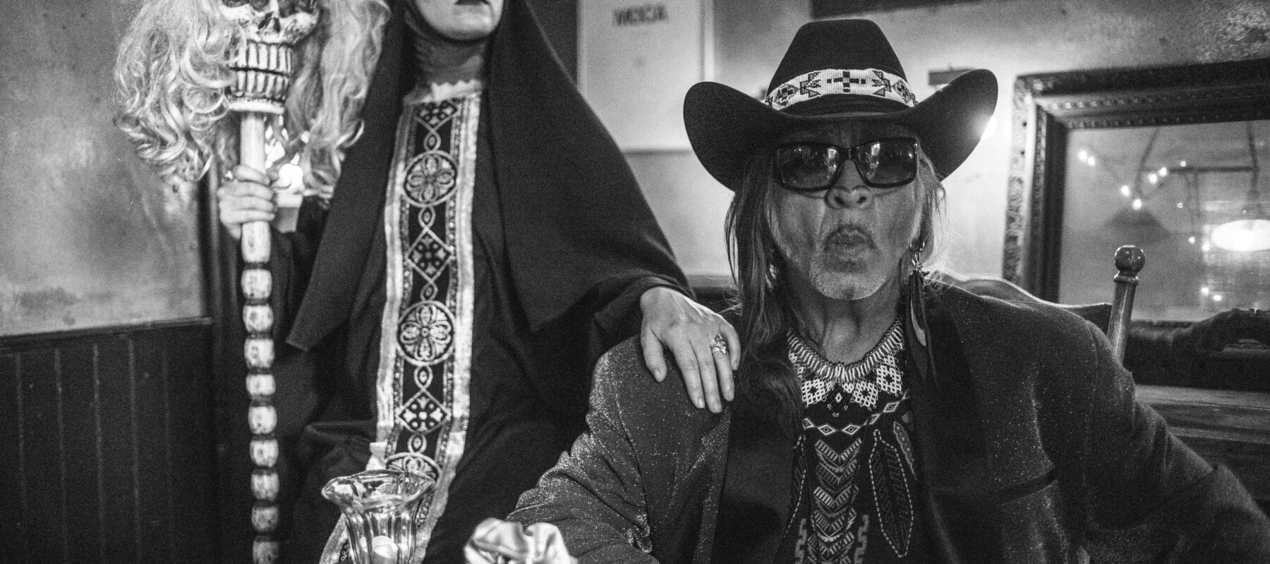 The Artist Guillermo Gomez-Pena and wife pose together in a dark room.