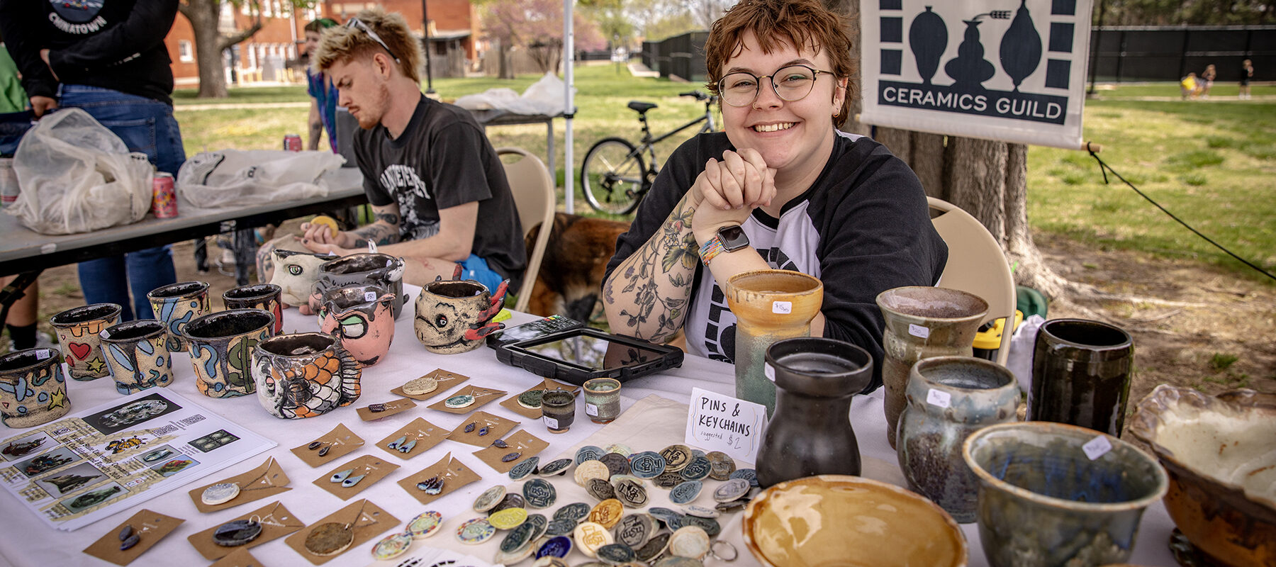 Young artists are selling their work in a tent.