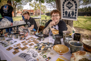 Young artists are selling their work in a tent.