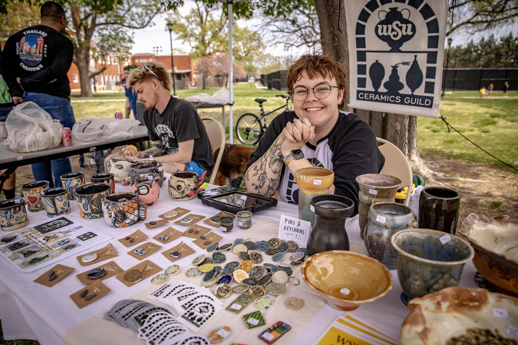 Young artists are selling their work in a tent.