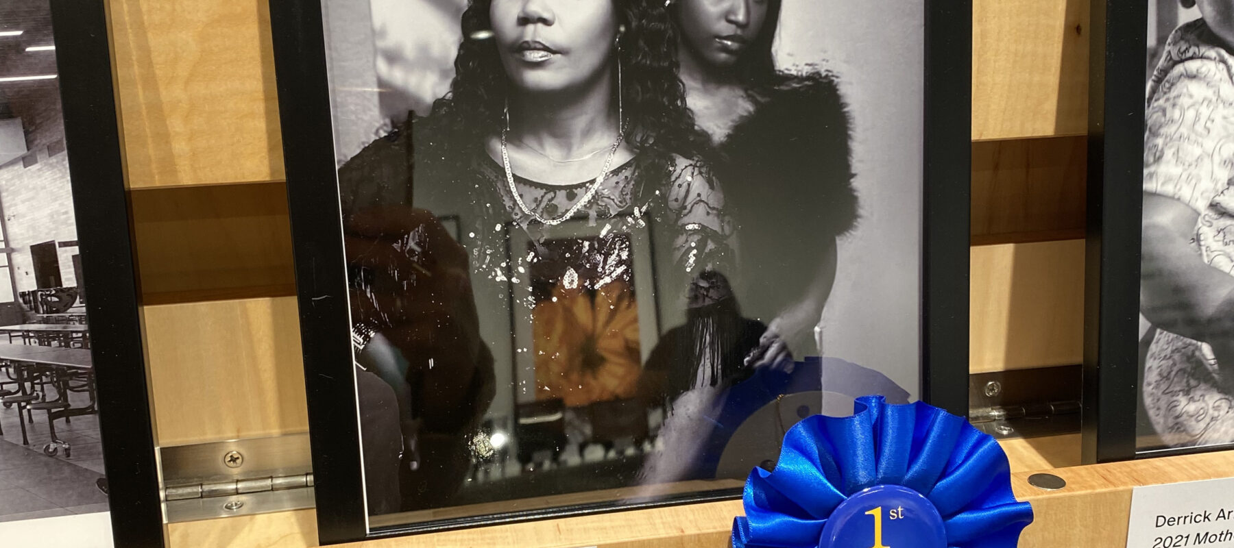 Award-winning photo of two young women, designated with a blue ribbon.